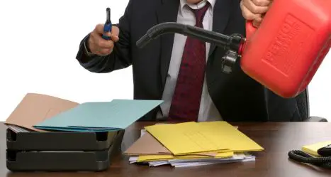 Businessman about to set fire to a pile of documents